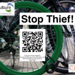 Green wheel padlocked to another bike. QR code links to www.recyculture.co.uk Search 'Stop Thief'